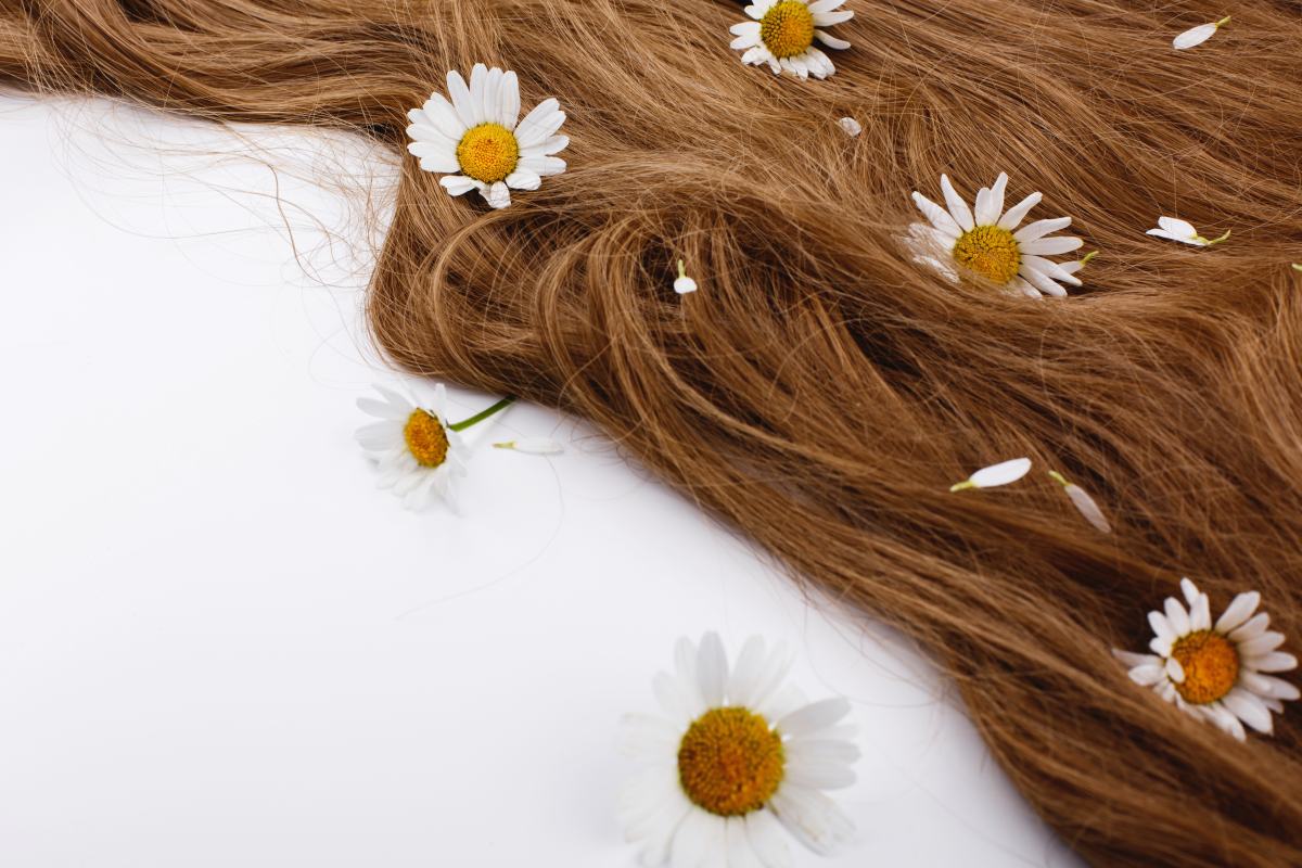 Cabello castaño ondulado adornado con margaritas